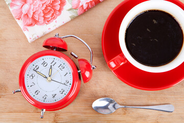 An alarm clock and a cup of coffee