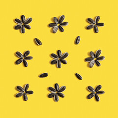 Obraz premium Pattern fron black sunflower seeds inscribed in square on yellow background. Raw whole grains