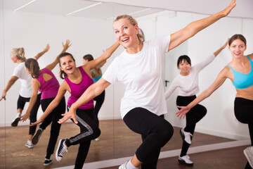 Cheerful different ages women learning swing steps at dance class. High quality photo