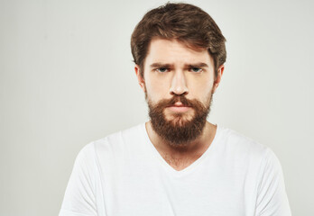 Obraz premium Bearded man in white T-shirt puzzled look sad face cropped look