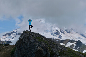 Woman in tree position meditating by glacier. Mount Baker. Washington State. USA 