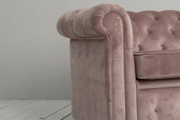 a classic pink sofa sits in a white room on a wooden floor. copy space