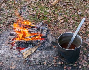 Fish soup boils in cauldron at the stake. Hot fresh food to prepare in the woods. camping kitchen....