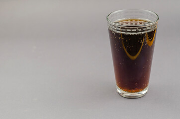 Glass of soda on a gray background.