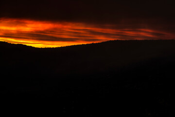 red fiery sky and dark clouds cover the summer Yosemite sky due to a forest fire.