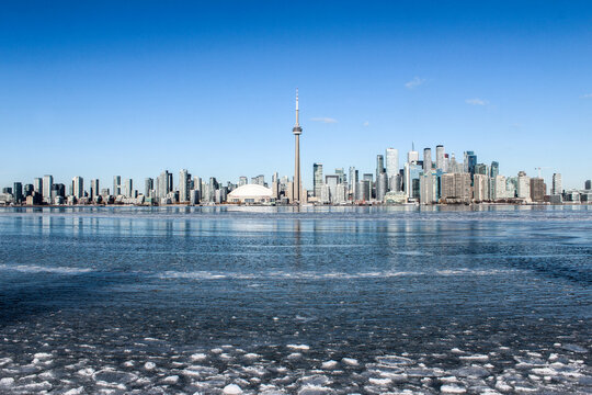 Toronto city skyline in winter overlooking Lake Ontario with frozen ice on a sunny day
