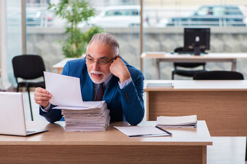 Obraz premium Old male boss employee working in the office