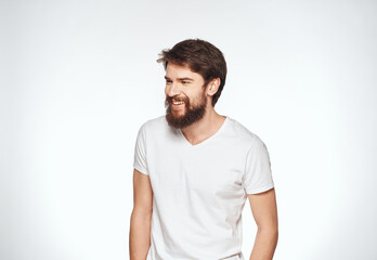 Emotional guy in a white t-shirt on a light background emotions model cropped view of a student