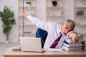 Old male employee in blood transfusion concept