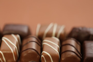 Chocolates assortment.Chocolate sweets.Chocolate pattern. Candy close-up on a brown background.dark milk chocolates set.Set of different chocolates.Sweet dessert