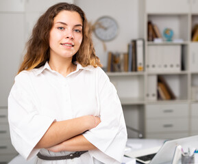 Closeup portrait of successful happy young business woman in office and looking at camera