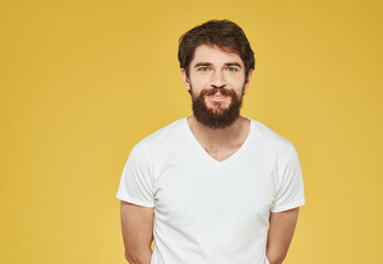 Obraz premium portrait of a man in a white t-shirt on a yellow background cropped view Copy Space