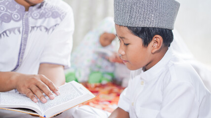 Asian Muslim families read the quran after prayers