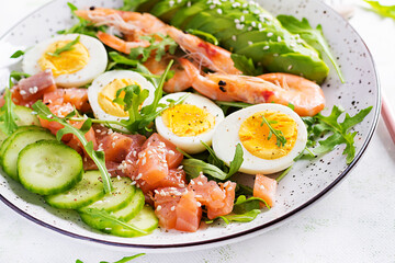 Ketogenic diet breakfast. Salt salmon salad with boiled shrimps, prawns, cucumbers, arugula, eggs and avocado. Keto, paleo lunch.
