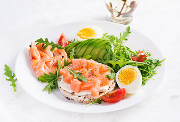 Ketogenic diet breakfast. Salt salmon salad with boiled shrimps, prawns, tomatoes, arugula, eggs and avocado. Keto, paleo lunch.