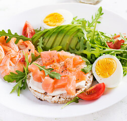 Ketogenic diet breakfast. Salt salmon salad with boiled shrimps, prawns, tomatoes, arugula, eggs and avocado. Keto, paleo lunch.