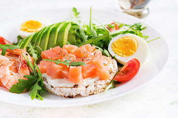 Ketogenic diet breakfast. Salt salmon salad with boiled shrimps, prawns, tomatoes, arugula, eggs and avocado. Keto, paleo lunch.