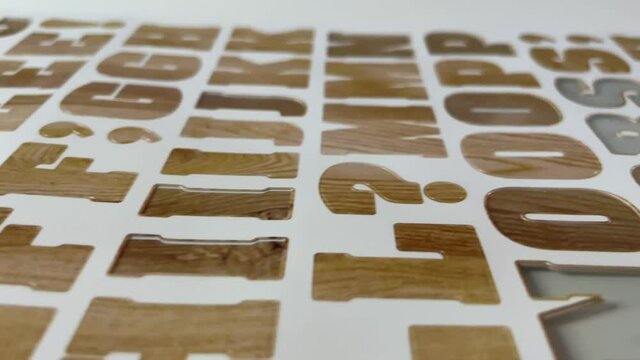 Close-up of letter stickers with wooden pattern printed on it with white studio background - children kids school project and artwork sticker letter alphabet pack - arts and crafts