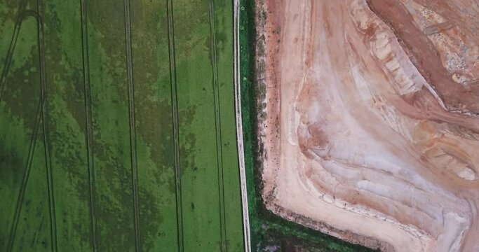 Top down aerial view of beautiful green field next to gravel pit, Essenbach, Bavaria . Environmental damage concept