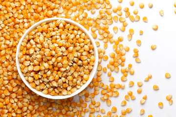 Close-up of organic yellow corn seed or maize (Zea mays) in a white ceramic bowl with the gradient background of corn seed. Top view 