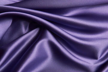 Obraz premium Purple silk fabric background, close-up. Smooth violet satin cloth texture