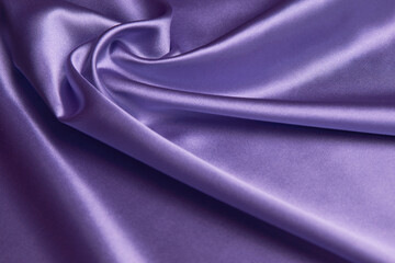 Purple silk fabric background, close-up. Smooth violet satin cloth texture