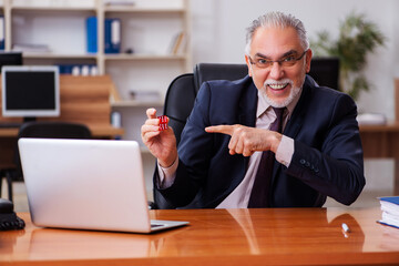 Old male employee in gambling concept at workplace