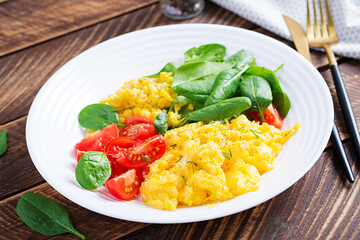 Breakfast. Scrambled eggs with cherry tomatoes, spinach  and corn.