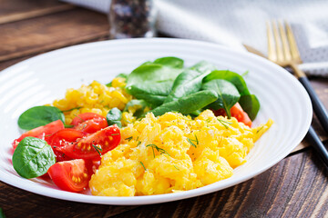 Breakfast. Scrambled eggs with cherry tomatoes, spinach  and corn.