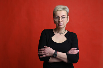 Portrait of cute caucasian blond woman in glasses on red background