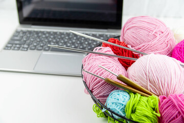 Online knitting training. View from above on the laptop, yarn and spokes.