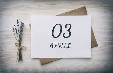 April 03. 03th day of the month, calendar date.White blank of paper with a brown envelope, dry bouquet of lavender flowers on a wooden background. Spring month, day of the year concept