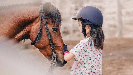 Asian school kid girl with horse ,riding or practicing horse ridding at horse ranch