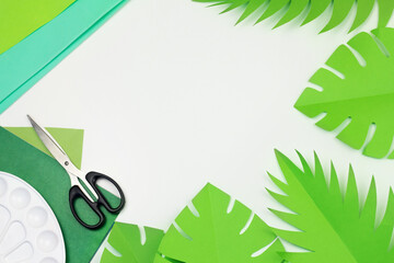 Jungle party decor banner with copy space top view. Handmade Hawaii decoration. Paper cut palm, monstera leaves craft