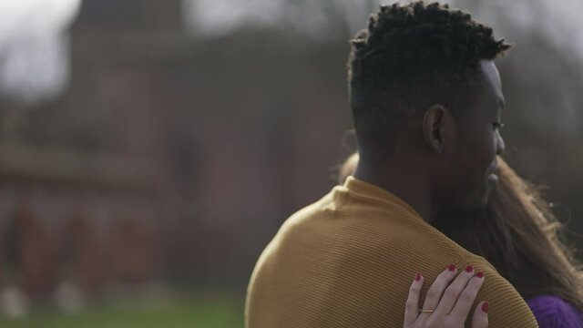Interracial couple empathic embrace. Young woman romantic connection with partner outside