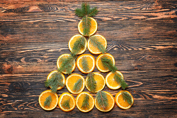 Christmas tree made of oranges and fir branches on wooden background
