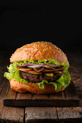 Close-up of home made tasty hamburger on wooden table.