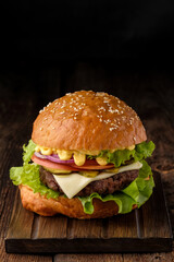 Close-up of home made tasty hamburger on wooden table.