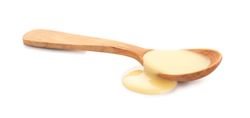 Wooden spoon of condensed milk on white background
