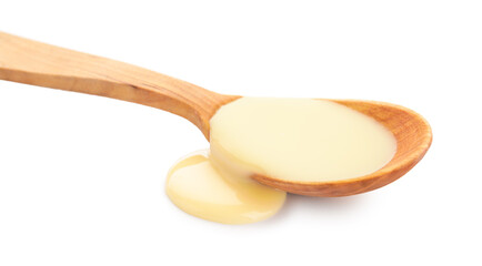 Wooden spoon of condensed milk on white background
