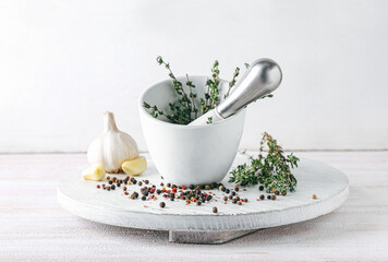 Mortar with spices and pestle on light background