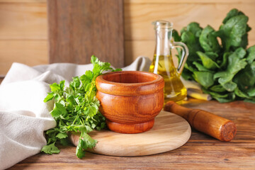 Mortar with spices and pestle on wooden background
