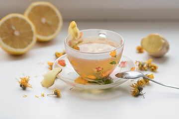 Green tea in a beautiful cup, with lemon and ginger