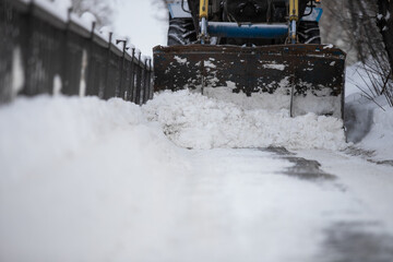 Snow plow and snow truck cleaning the streets during a snow storm in night maintenance action in...