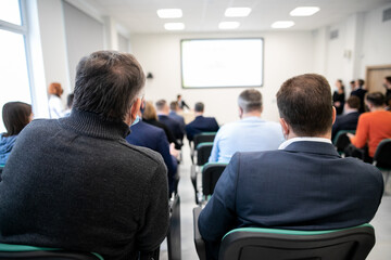 Row of business people listening to presentation at seminar