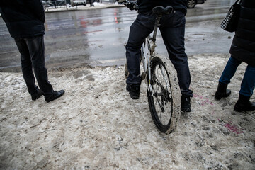 Slush.Asphalt road covered with melting dirty snow and mud on an early spring day.Road is not cleared of snow.Spring thaw.Snow melting.Large muddy puddle in the middle of the highway.