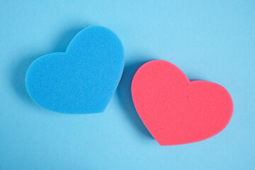 heart shape sponges on blue background copy space