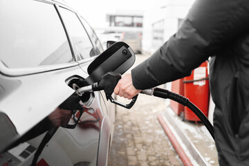 Male hand close-up refueling a black car
