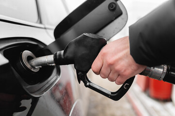 Male hand close-up refueling a black car