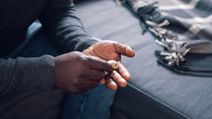Black man counting coins. Close up on the hands of poor man . High quality photo